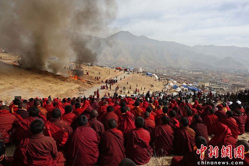 4月17日,众多地震遇难者遗体被火葬。图为众多僧侣为逝者祈祷。